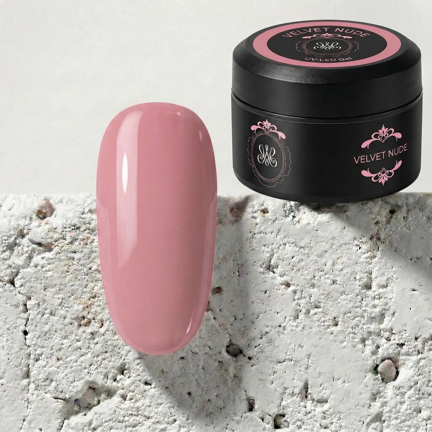 Velvet Nude Cover Builder Gel in schwarzer Studio‑Amelie‑Dose mit Farbtipp in sanftem Nude‑Ton auf Steinoberfläche.