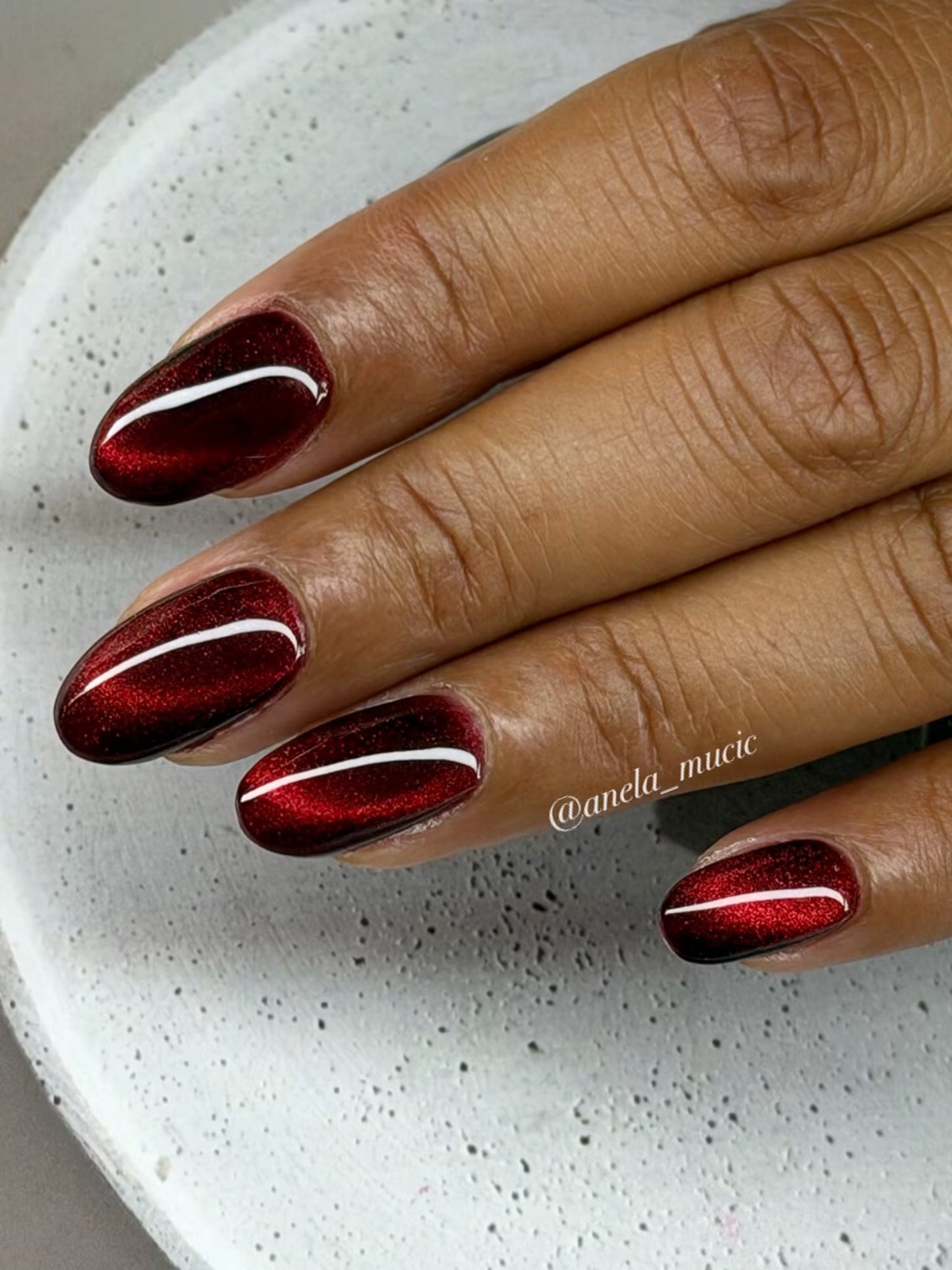 Tiefrote glitzernde Cat-Eye-Nägel mit klassischem, geschwungenem Magnetstreifen auf mehreren Fingern – Ergebnis aus dem Cat Eye Halbtageskurs bei Studio Amelie
