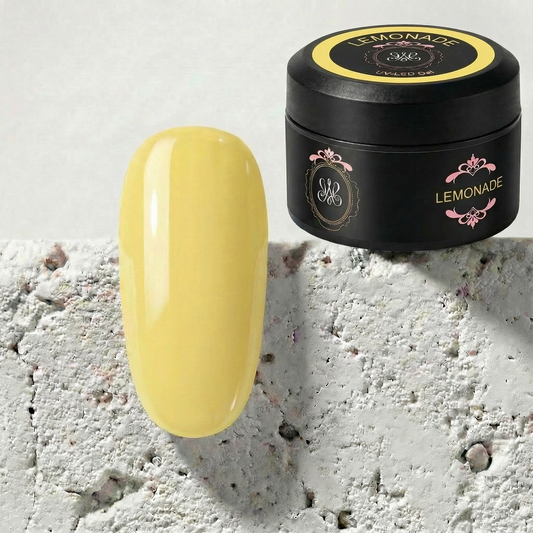 Studio Amelie Lemonade – Sanftes Pastellgelb Soft Color Builder Gel auf einem glänzenden Mustertipp, präsentiert neben dem schwarzen 15g Profi-Tiegel.