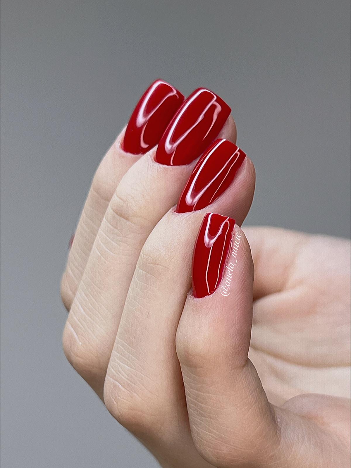 Hochglanz-Finish und präzise Nagelhaut-Arbeit bei einer roten Square-Modellage – Ergebnis einer Profi-Schulung.