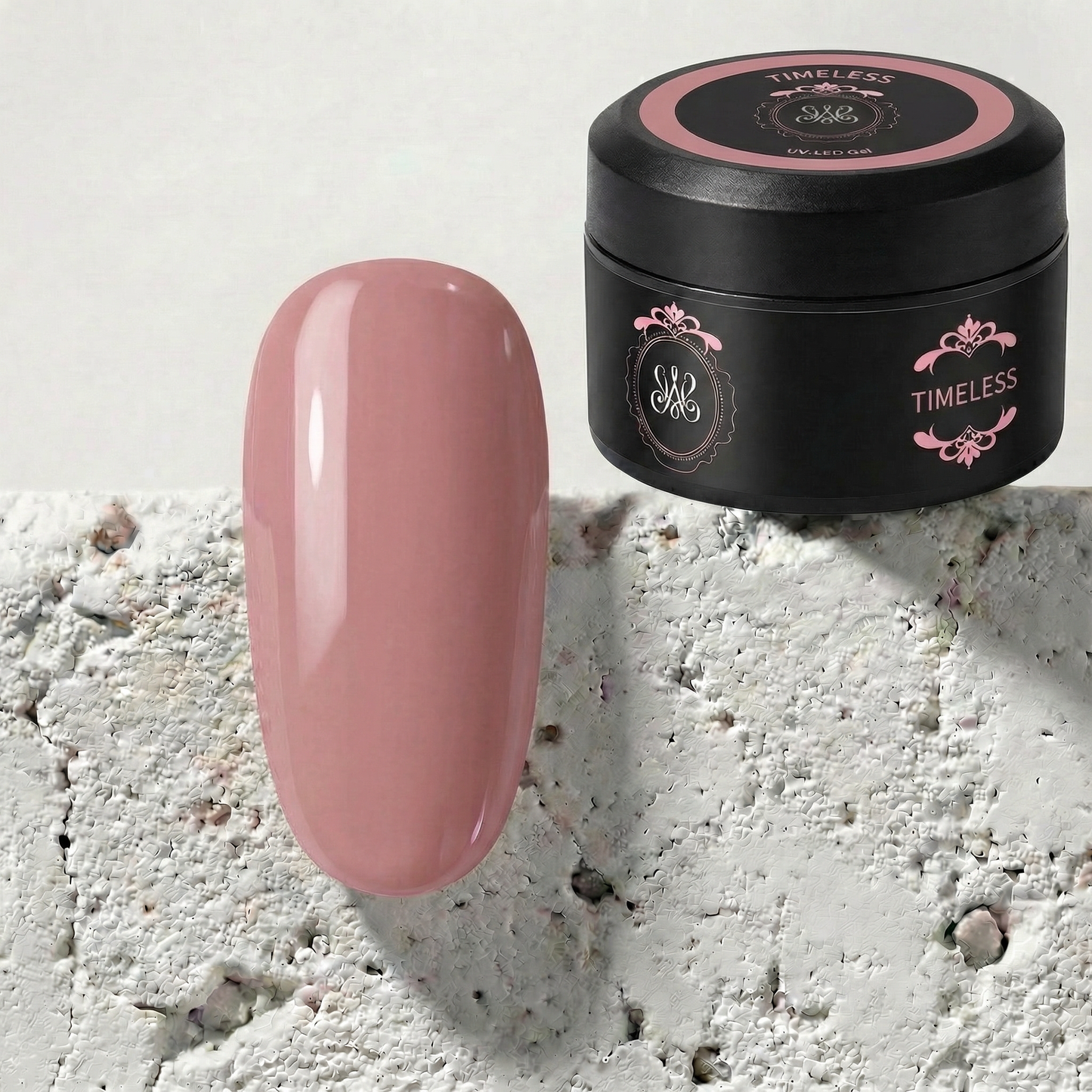 Studio Amelie No-File Aufbaugel „Timeless“ im schwarzen Tiegel mit einem farblich passenden, glänzenden Nude-Rosé Tipp daneben.