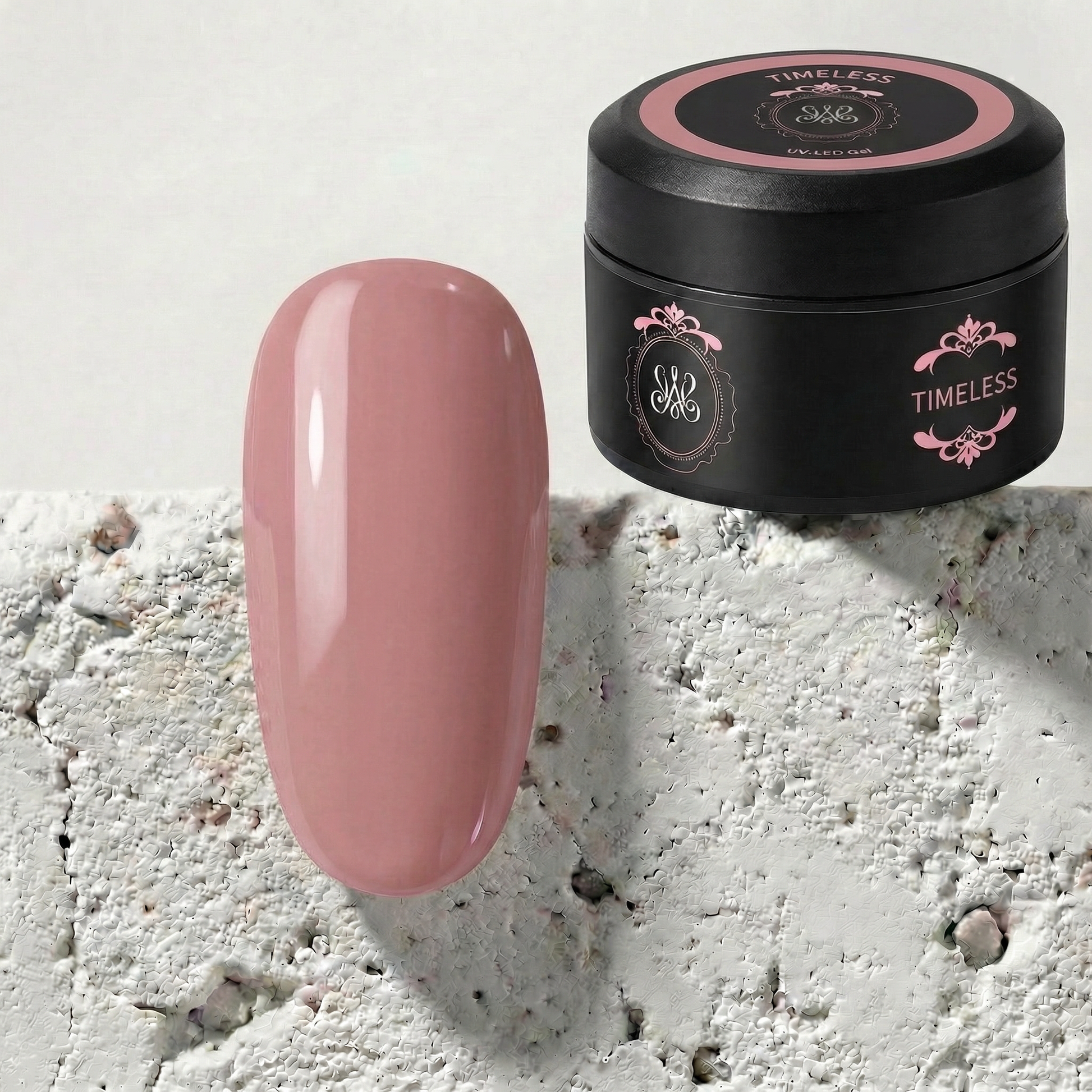 Studio Amelie No-File Aufbaugel „Timeless“ im schwarzen Tiegel mit einem farblich passenden, glänzenden Nude-Rosé Tipp daneben.