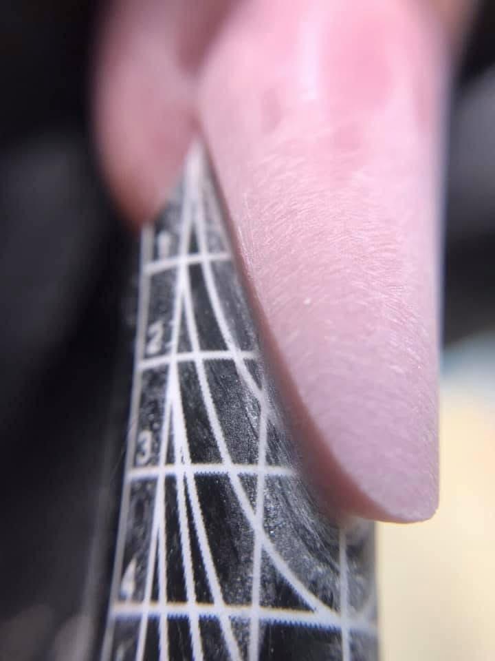 Nahaufnahme eines präzisen Nagelaufbaus mit Cover-Gel auf einer Stiletto-Schablone, demonstriert Sergey Lavrukhins kompromisslose Architektur.